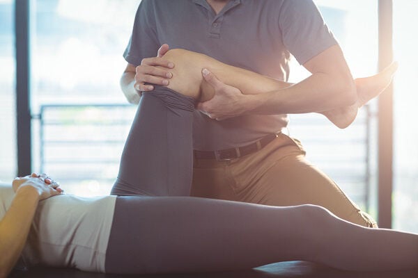 Physical Therapist stretching someone's leg Physical Therapist stretching someone's leg