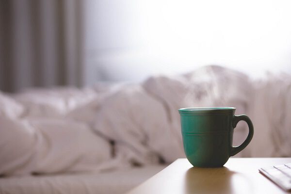 A green mug on a desk A green mug on a desk