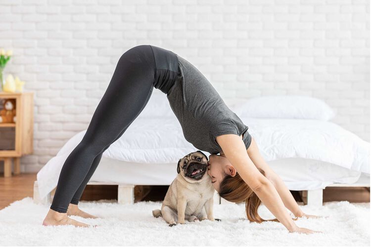 woman doing yoga with her dog