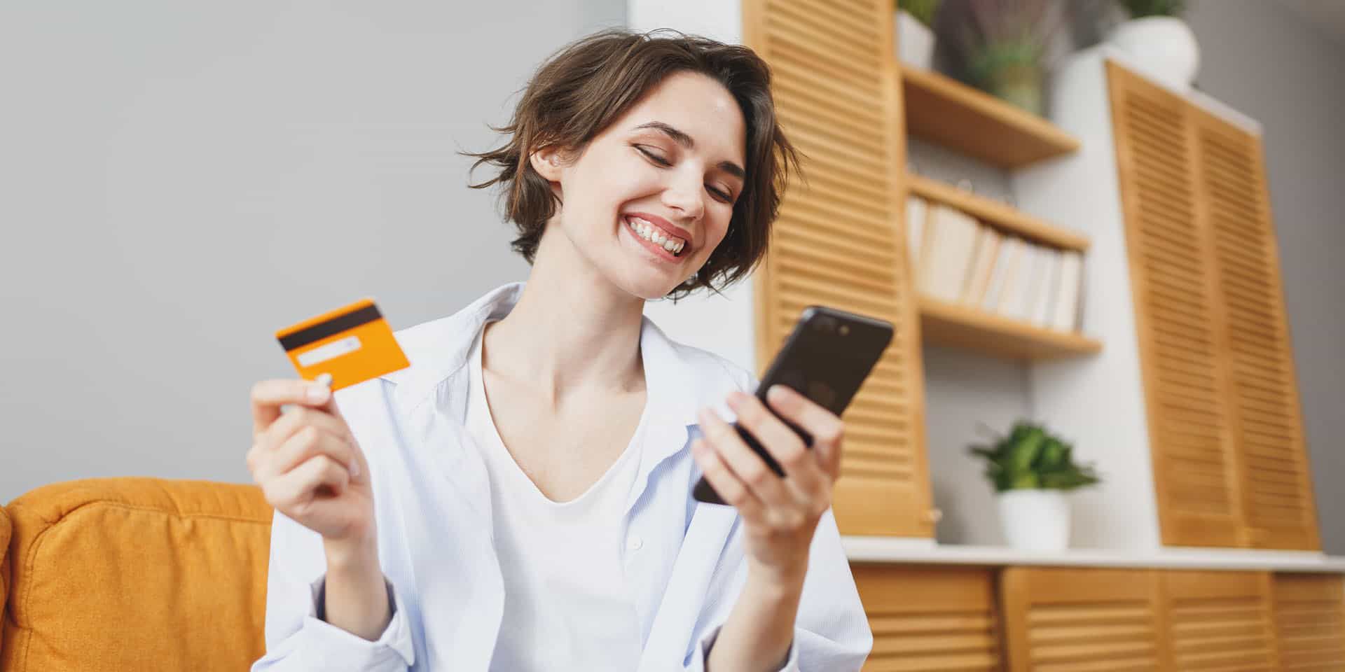 Woman smiling while holding FSA card and smart phone
