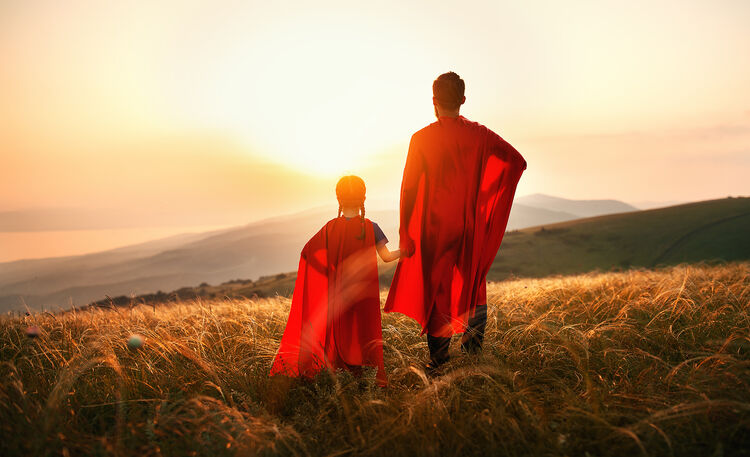 Father and Daughter Wearing Capes in a Field
